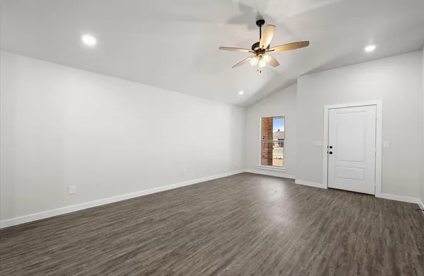a view of an empty room with wooden floor