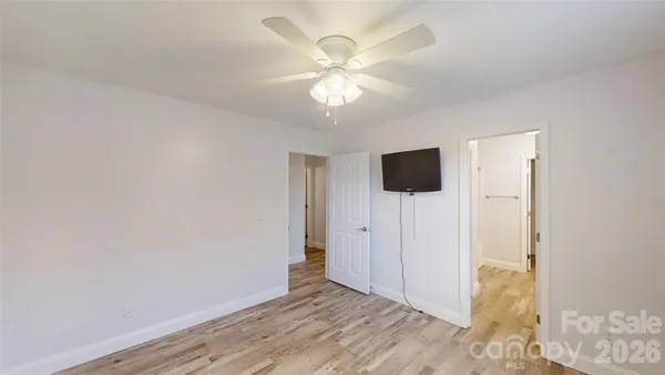a view of a livingroom with wooden floor and a ceiling fan