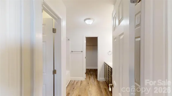 a view of a hallway with wooden floor and staircase
