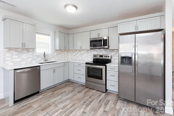 a kitchen with a refrigerator stove and microwave