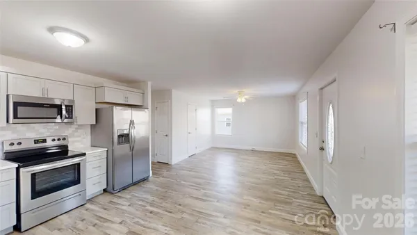 a kitchen with granite countertop a refrigerator and a stove top oven