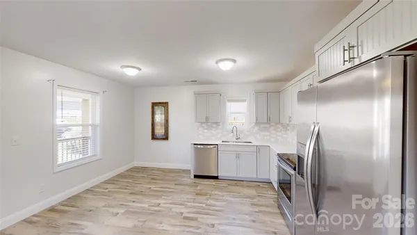 a kitchen with stainless steel appliances granite countertop a refrigerator and a sink