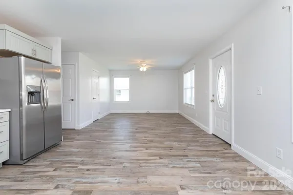 a view of an empty room with window and wooden floor