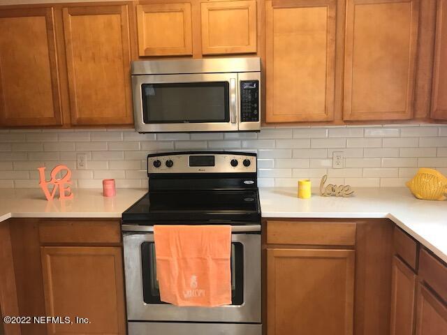 426 Dutton Island Road West Jacksonville, FL 32233 - Photo 8 of 22 a kitchen with stainless steel appliances wooden cabinets and a stove top oven