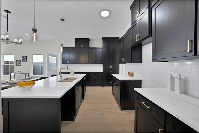 a kitchen with stainless steel appliances granite countertop a sink a stove and a wooden floors