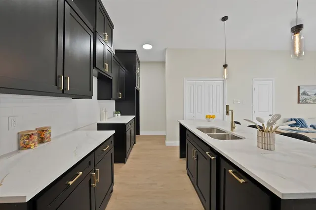 a kitchen with granite countertop a sink a counter space appliances and cabinets