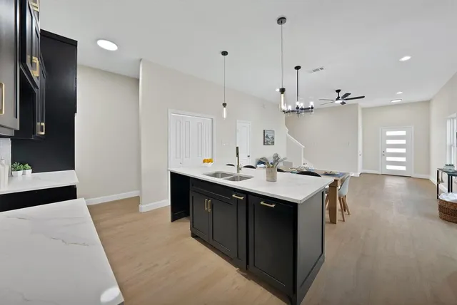 a kitchen with a sink a center island a stove a dining table and chairs