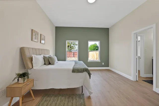 a bedroom with a bed and wooden floor