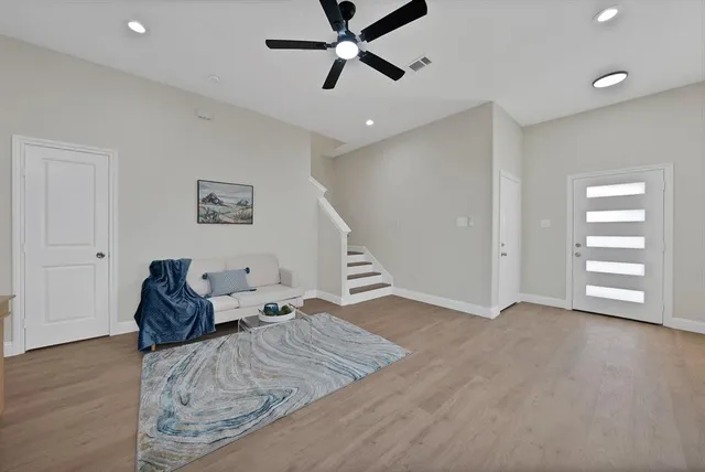 a living room with furniture and wooden floor