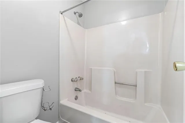 a white bath tub sitting next to a white toilet and a shower