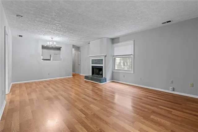 a view of empty room with wooden floor and fireplace