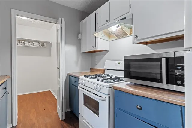 a kitchen with stainless steel appliances a stove a microwave and cabinets