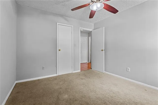 an empty room with a ceiling fan and a fan