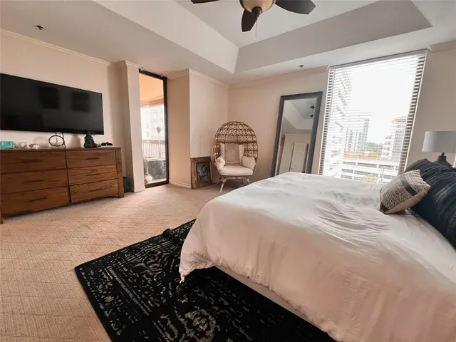 a bedroom with a bed and a flat tv screen on dresser