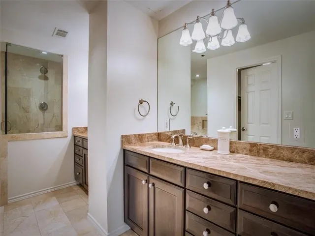 a bathroom with a granite countertop sink and a mirror