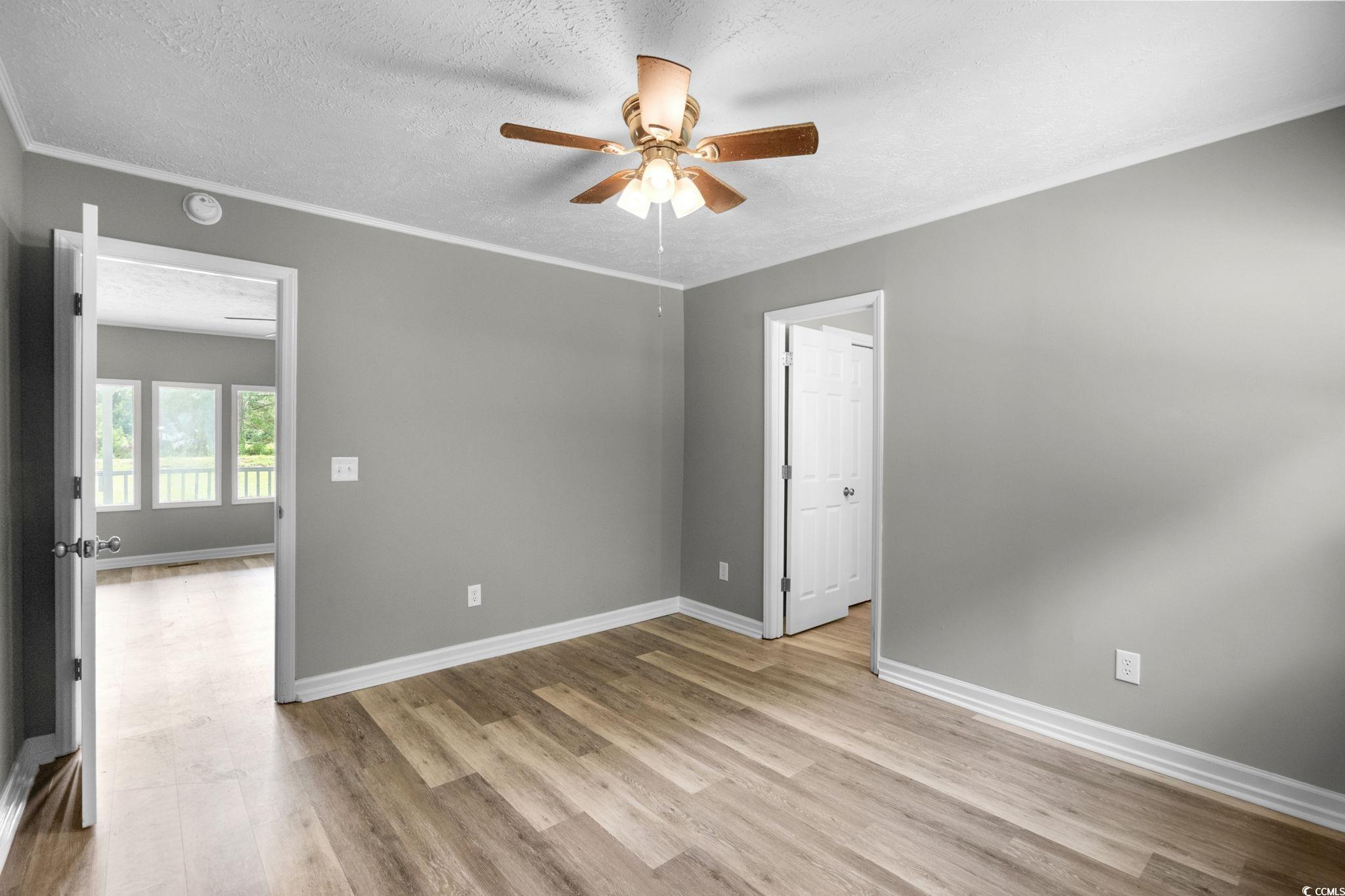 450 Highway 348 Loris, SC 29569 - Photo 19 of 37 Empty room featuring a textured ceiling, light wood-style floors, ceiling fan, and crown molding