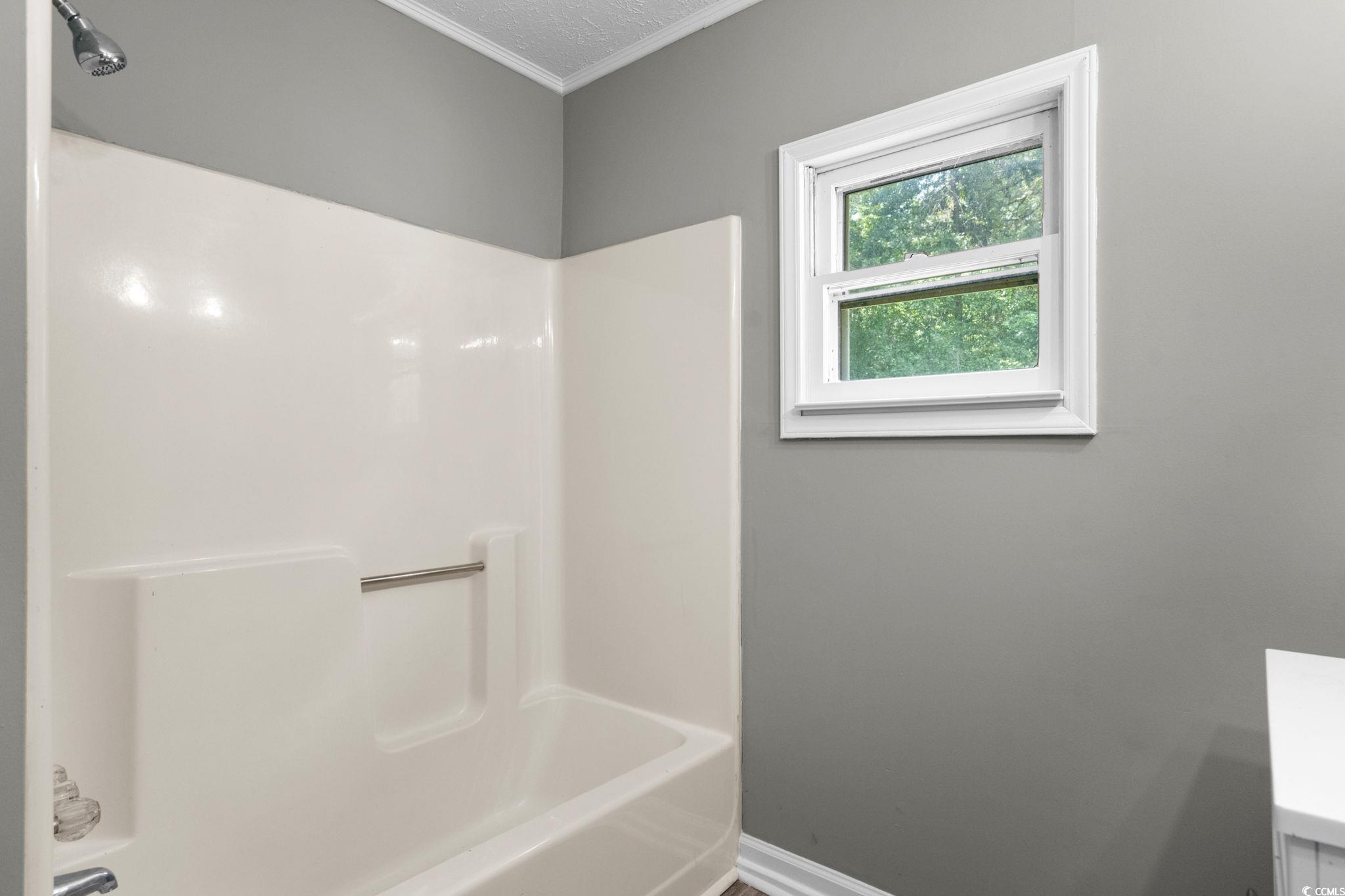 450 Highway 348 Loris, SC 29569 - Photo 21 of 37 Bathroom featuring shower combination, vanity, and crown molding