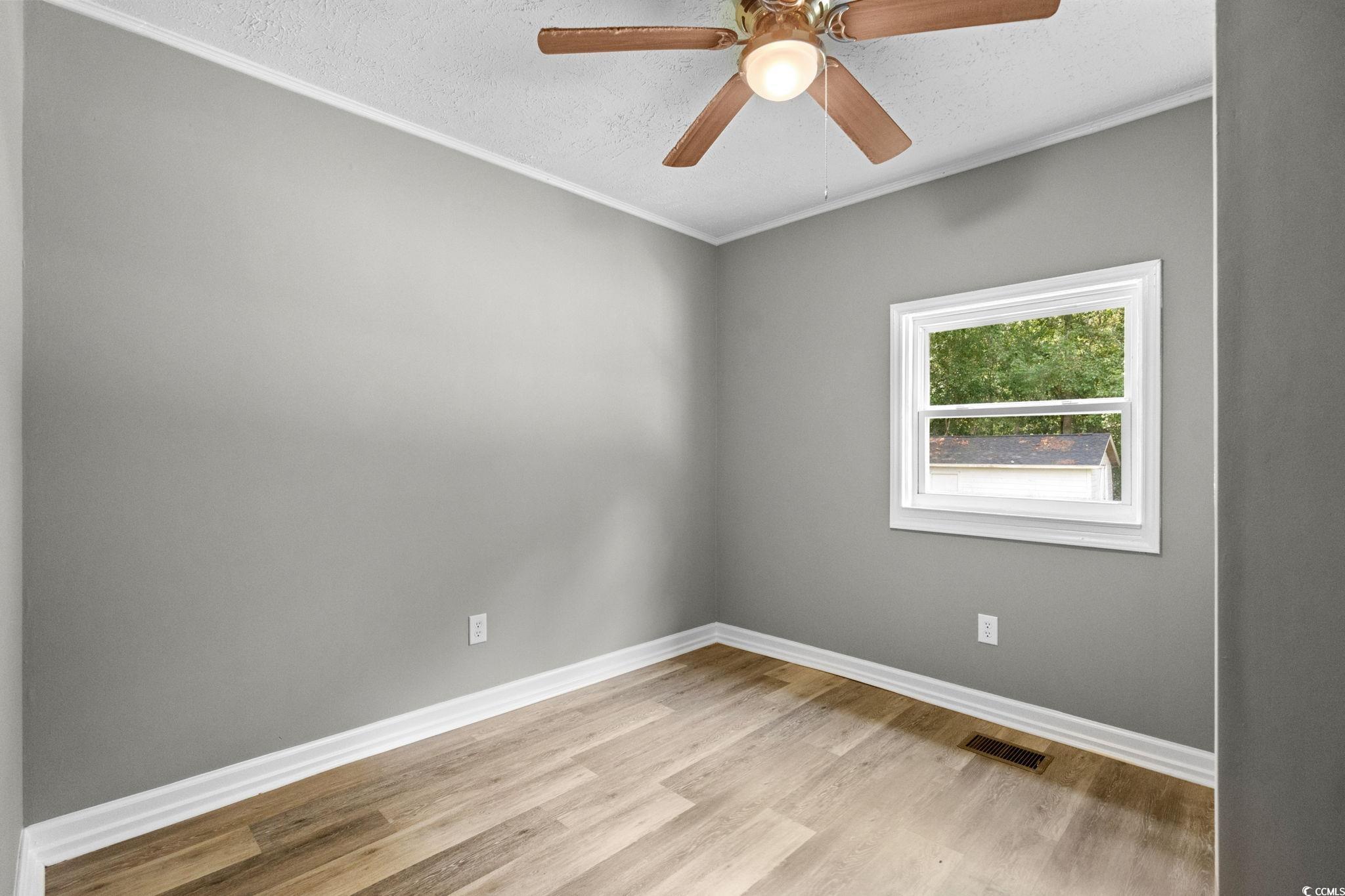 450 Highway 348 Loris, SC 29569 - Photo 23 of 37 Empty room featuring crown molding, light wood-type flooring, a textured ceiling, and ceiling fan