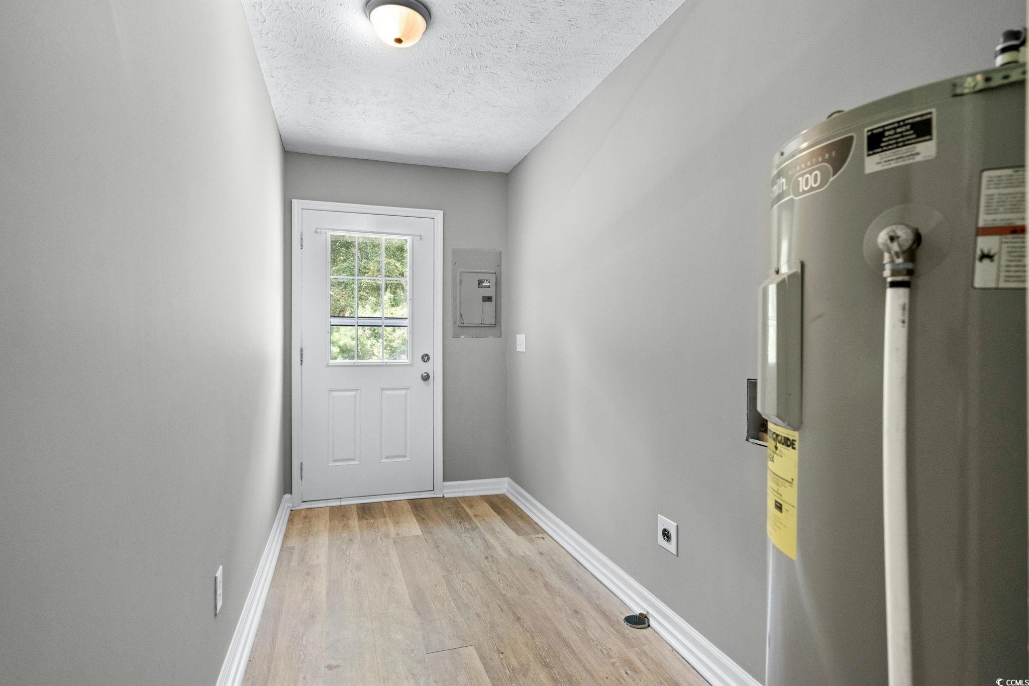 450 Highway 348 Loris, SC 29569 - Photo 26 of 37 Doorway featuring water heater, wood finished floors, a textured ceiling, and electric panel