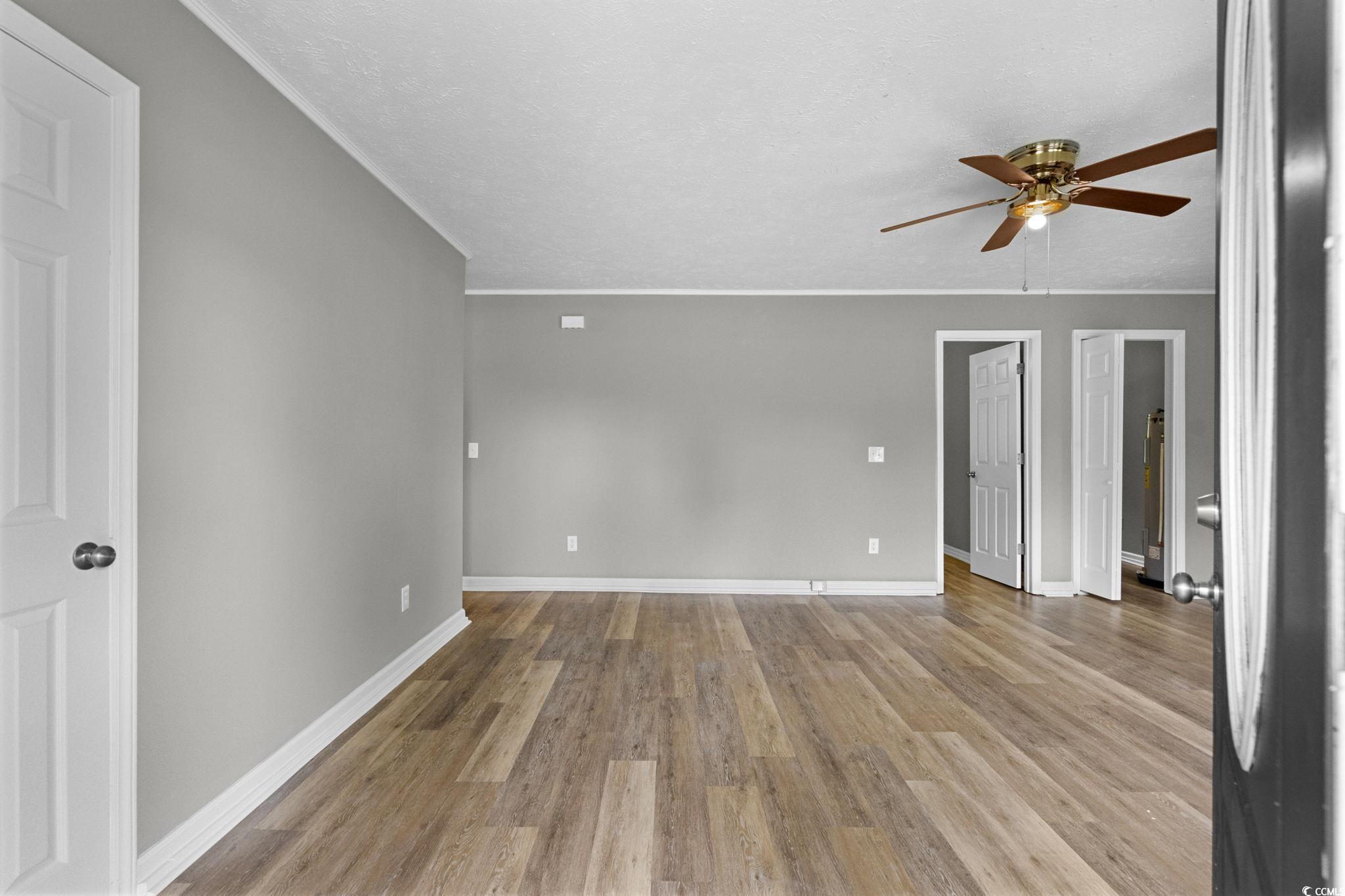 450 Highway 348 Loris, SC 29569 - Photo 4 of 37 Unfurnished room featuring light wood-style flooring, a textured ceiling, a ceiling fan, and crown molding