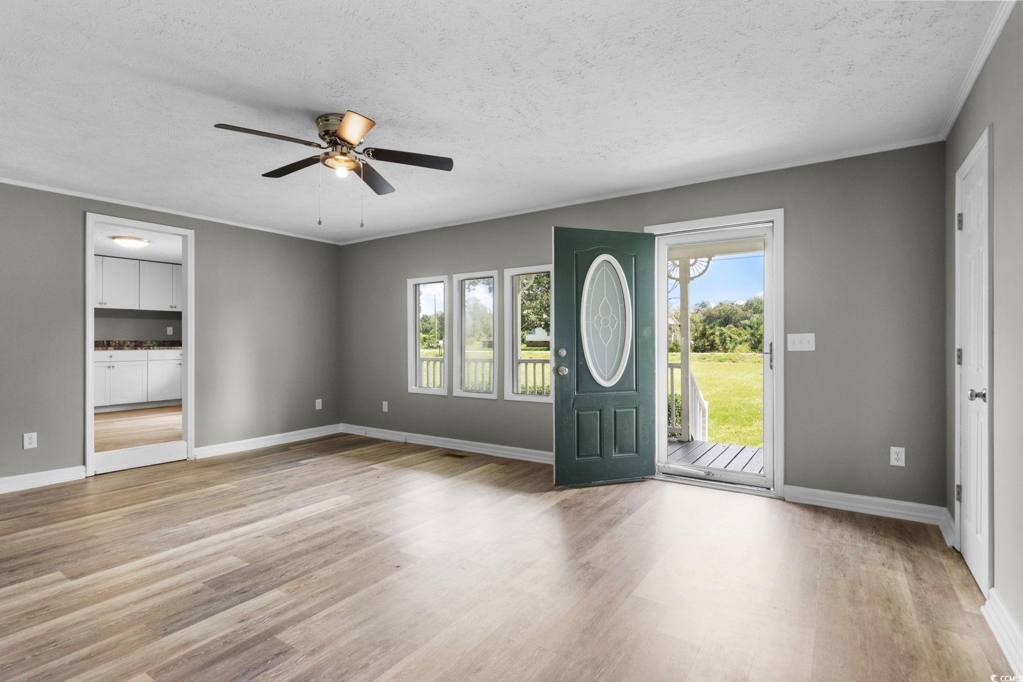 450 Highway 348 Loris, SC 29569 - Photo 5 of 37 Entryway featuring a textured ceiling, ceiling fan, light wood-type flooring, and crown molding