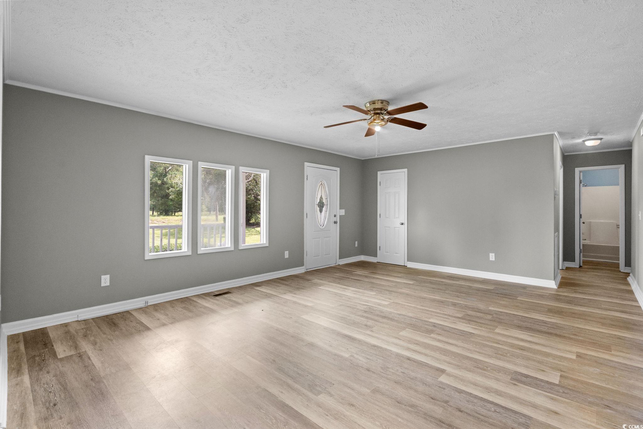 450 Highway 348 Loris, SC 29569 - Photo 7 of 37 Unfurnished living room featuring light wood-type flooring, a textured ceiling, and a ceiling fan