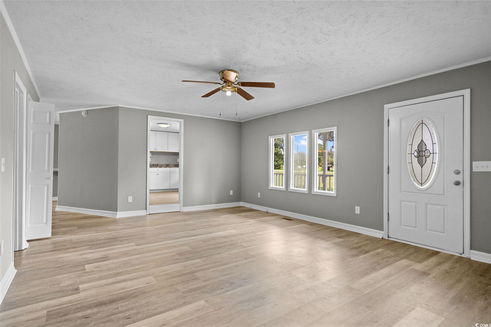 450 Highway 348 Loris, SC 29569 - Photo 9 of 37 Foyer entrance featuring light wood-type flooring, a textured ceiling, and a ceiling fan