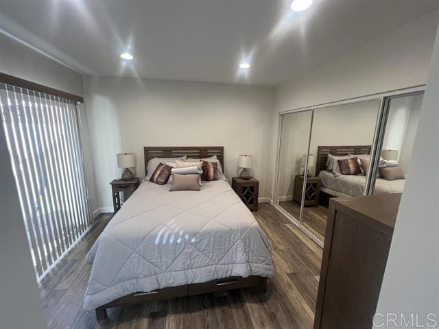 7061 Estrella De Mar Road, Unit 66 Carlsbad, CA 92009 - Photo 8 of 17 a bedroom with a bed and wooden floor