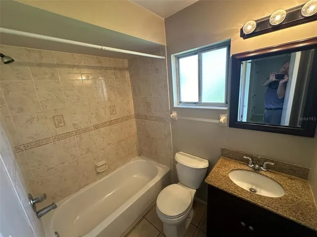 a bathroom with a granite countertop sink toilet mirror and shower