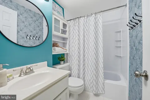 a bathroom with a toilet sink and shower curtain