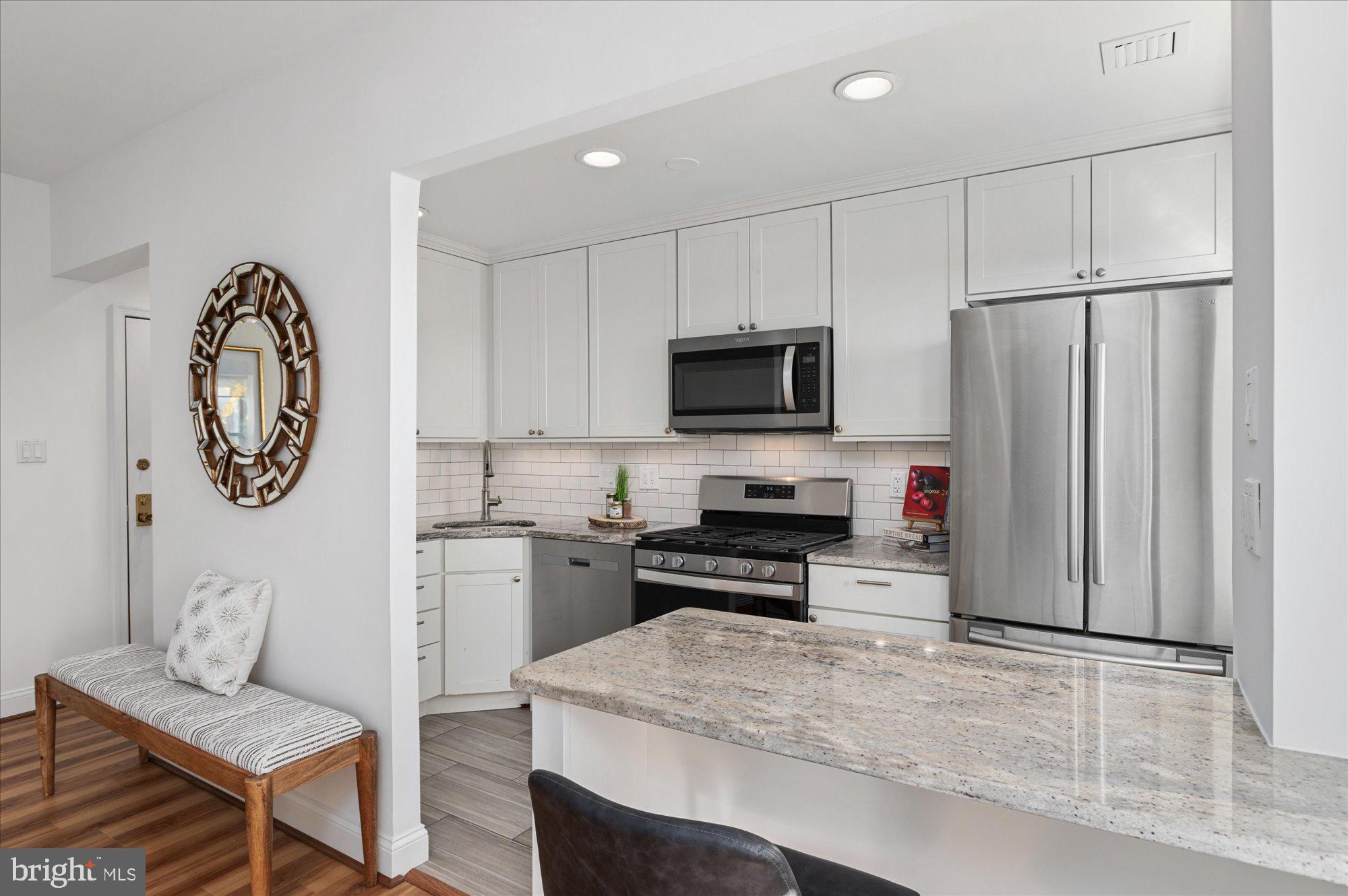 2127 California Street Northwest, Unit 803 Washington, DC 20008 - Photo 10 of 22 a kitchen with stainless steel appliances a stove a sink and a refrigerator
