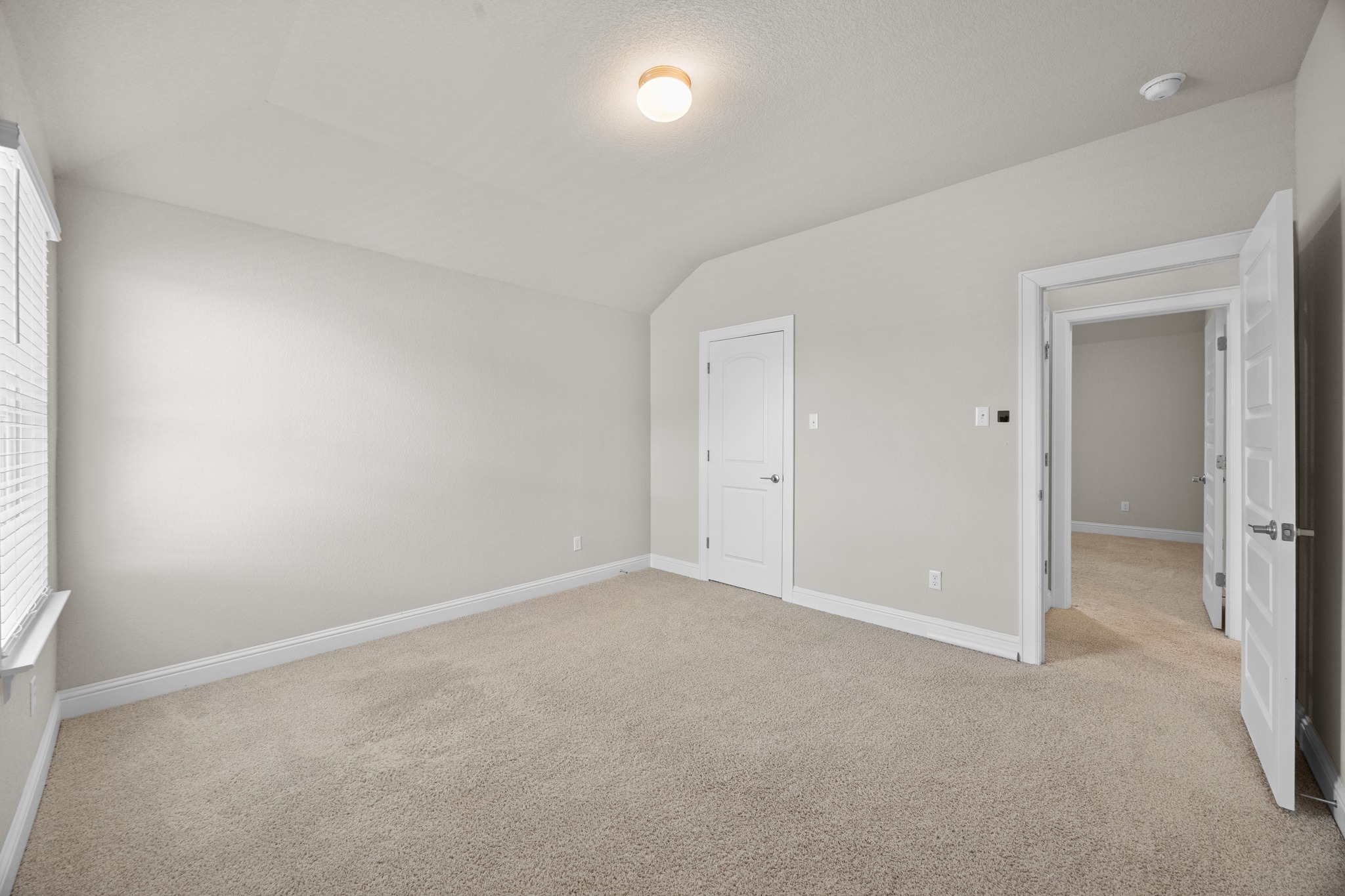 213 Graver Street Georgetown, TX 78626 - Photo 26 of 33 A well-proportioned bedroom with sloped ceilings and plush carpeting.