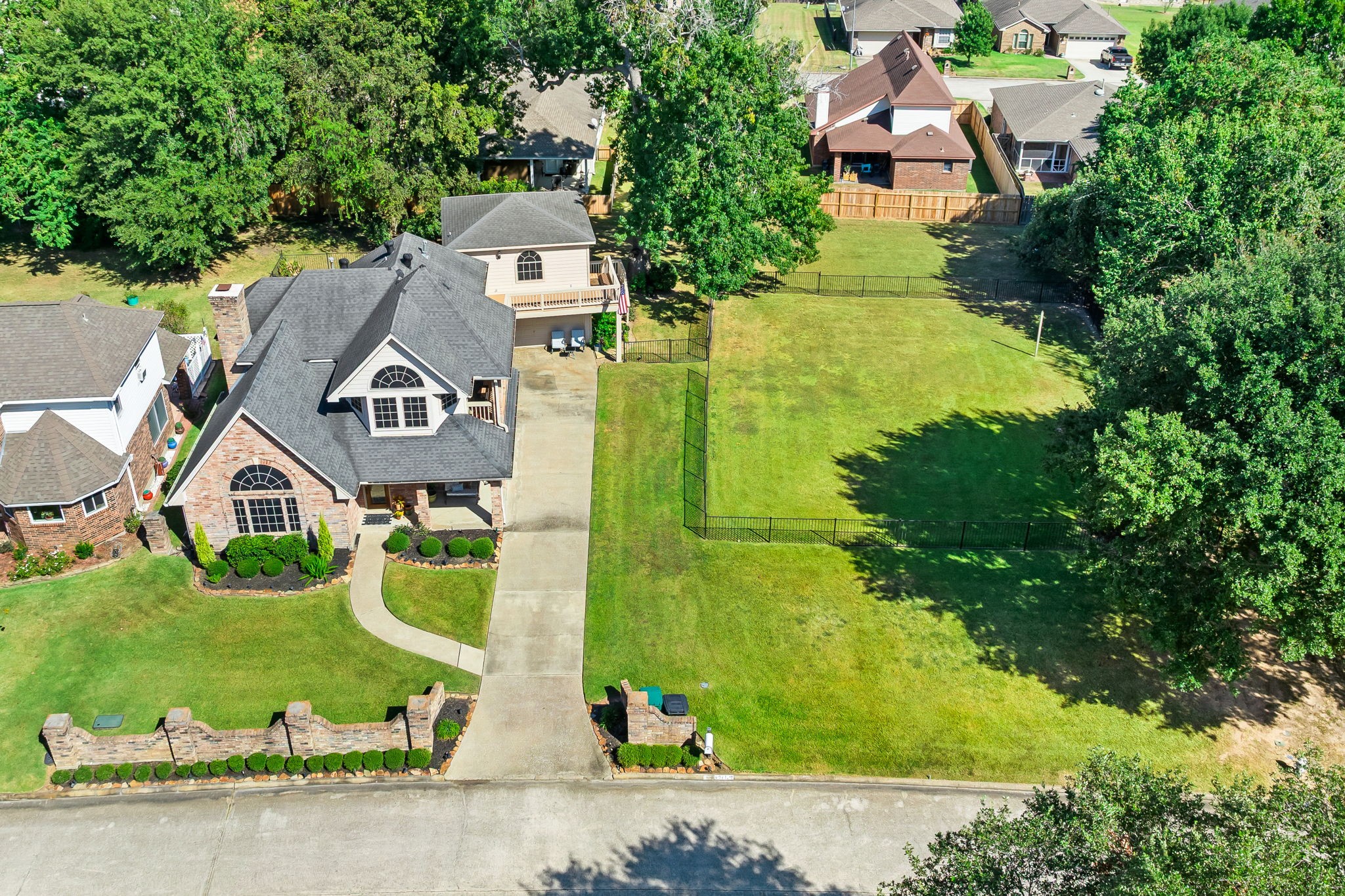 6971 Breezy Point Willis, TX 77318 - Photo 2 of 49 Seven Coves offers a so much more for those looking for an established community with matured trees, easements between properties in many areas and nice amenities. This home at 6971 Breezy Point is on a quiet cul-de-sac and as you can see here they also own the adjacent iron fenced lot that is not included in the home price, but can be purchased as well.