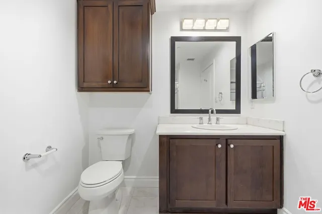 a bathroom with a toilet a sink and mirror