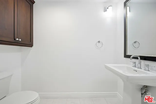 a bathroom with a sink a toilet and mirror