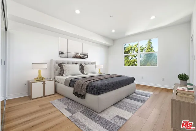 a bedroom with a large bed and a potted plant