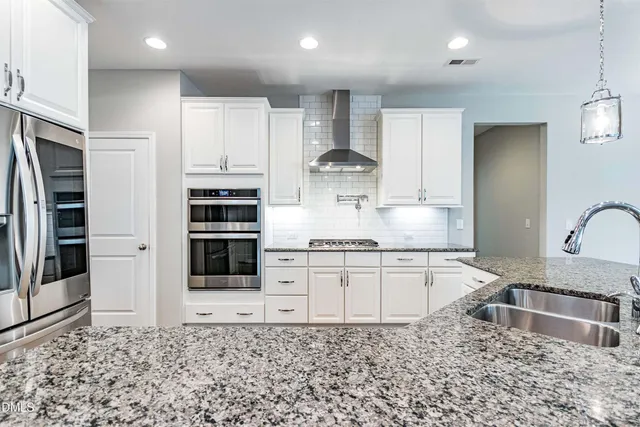 a kitchen with stainless steel appliances granite countertop a refrigerator and a sink