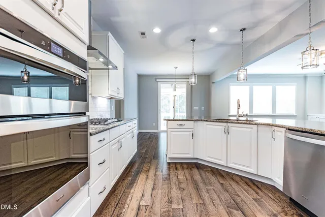 a large white kitchen with a stove a sink dishwasher and a refrigerator
