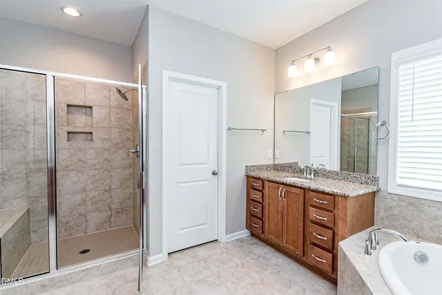 a bathroom with a granite countertop sink mirror and shower