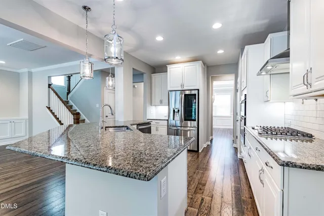 a kitchen with stainless steel appliances kitchen island granite countertop a sink and cabinets