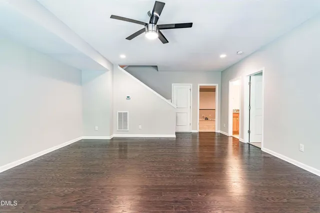 a view of an empty room with window and wooden floor