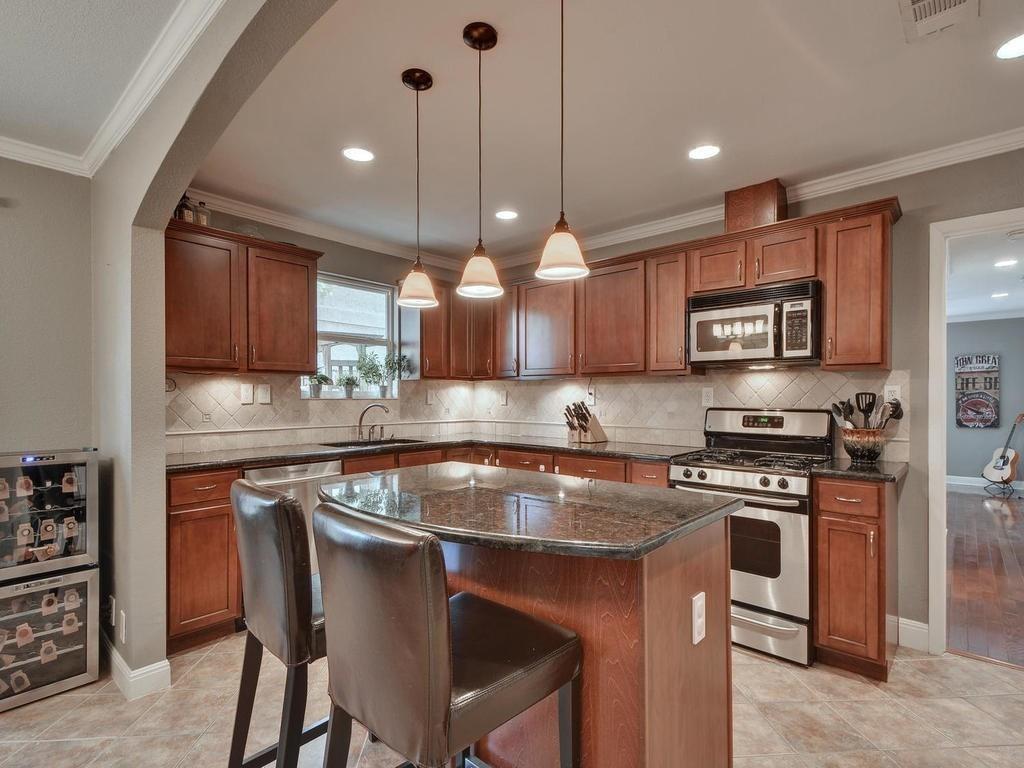 610 West N Loop Boulevard Austin, TX 78751 - Photo 2 of 29 The kitchen features rich wood cabinetry, granite countertops, and stainless steel appliances