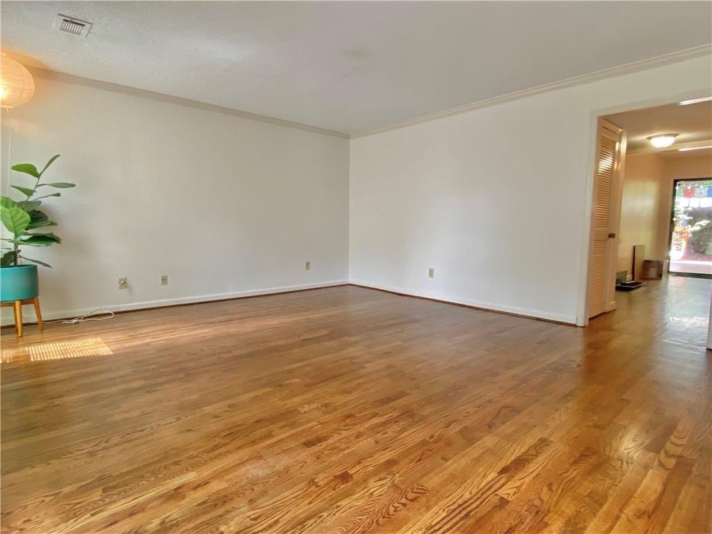 1148 Riverbend Club Drive Southeast Atlanta, GA 30339 - Photo 4 of 51 an empty room with wooden floor and a potted plant