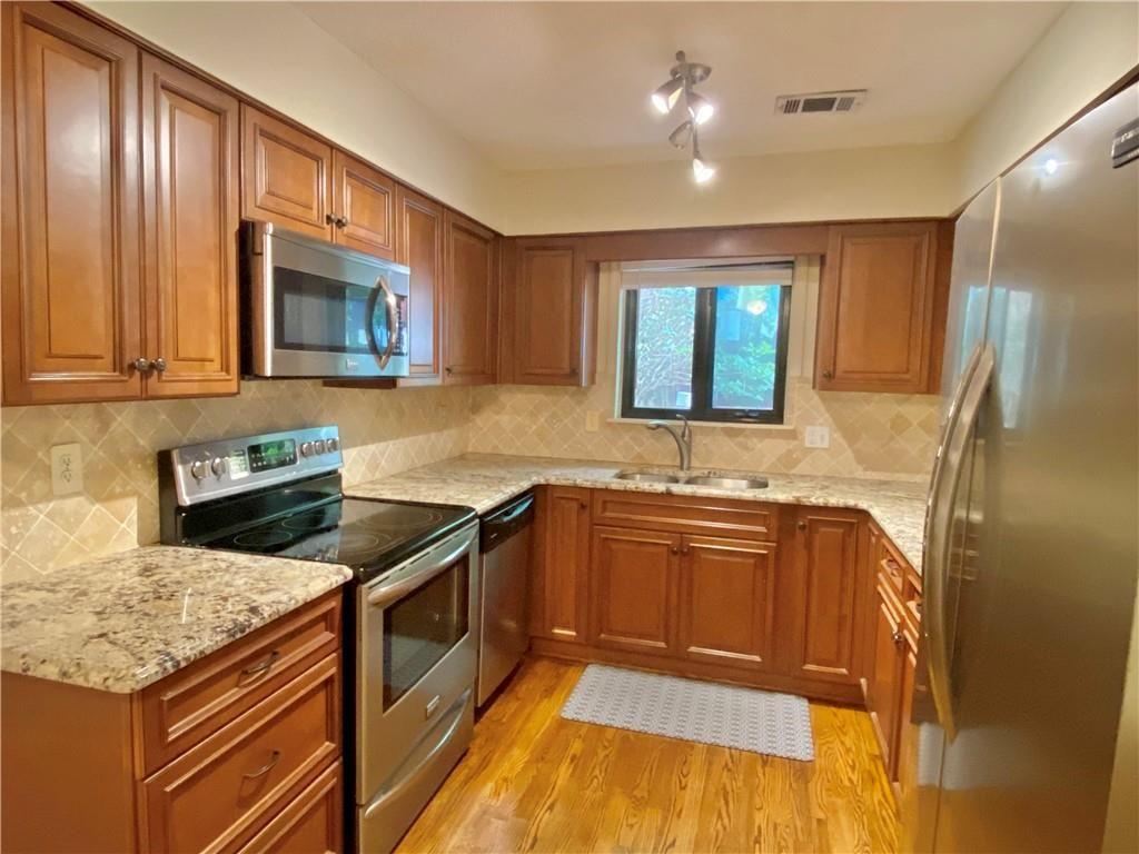 1148 Riverbend Club Drive Southeast Atlanta, GA 30339 - Photo 8 of 51 a kitchen with stainless steel appliances granite countertop hardwood floor sink stove and granite counter top