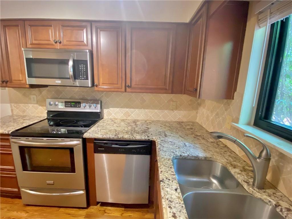 1148 Riverbend Club Drive Southeast Atlanta, GA 30339 - Photo 9 of 51 a kitchen with granite countertop a stove and a microwave