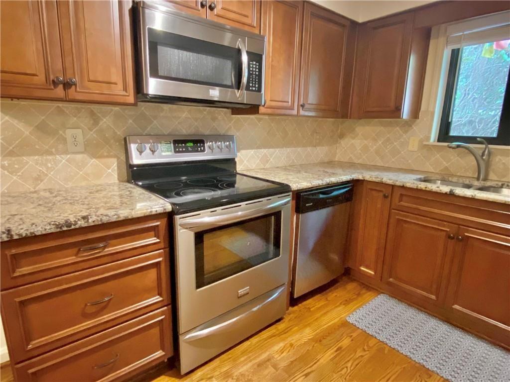 1148 Riverbend Club Drive Southeast Atlanta, GA 30339 - Photo 10 of 51 a kitchen with granite countertop a stove top oven microwave and cabinets