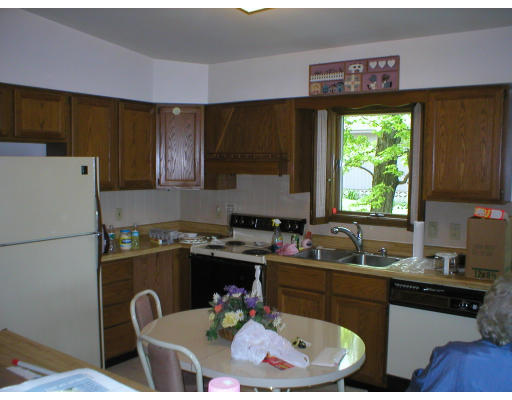 174 Manchaug Road Sutton, MA 01590 - Photo 4 of 7 a kitchen with a sink a stove and a refrigerator
