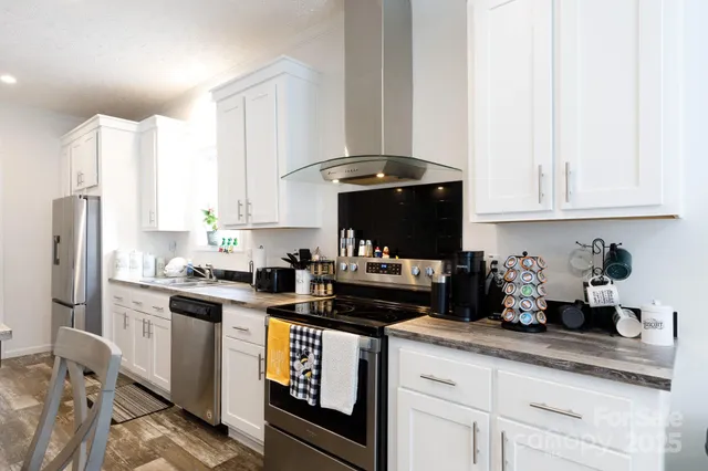 a kitchen with stainless steel appliances granite countertop a sink a stove and a refrigerator