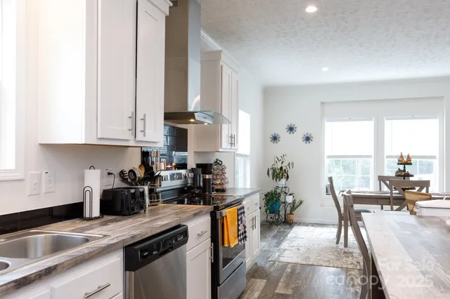 a kitchen with stainless steel appliances granite countertop a sink a stove and a refrigerator