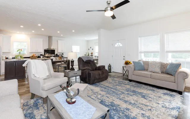 a living room with furniture kitchen view and a window